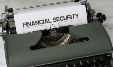 a close up of a typewriter with a financial security sign on it