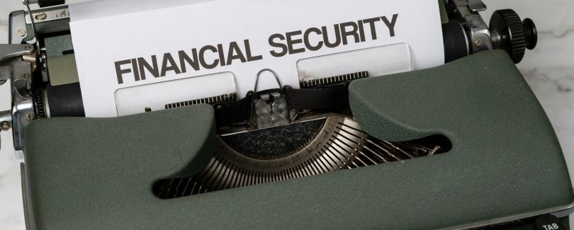 a close up of a typewriter with a financial security sign on it