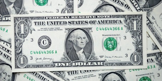 a pile of one dollar bills laying on top of each other