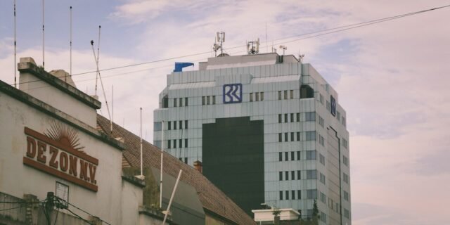 A modern building rises above older ones